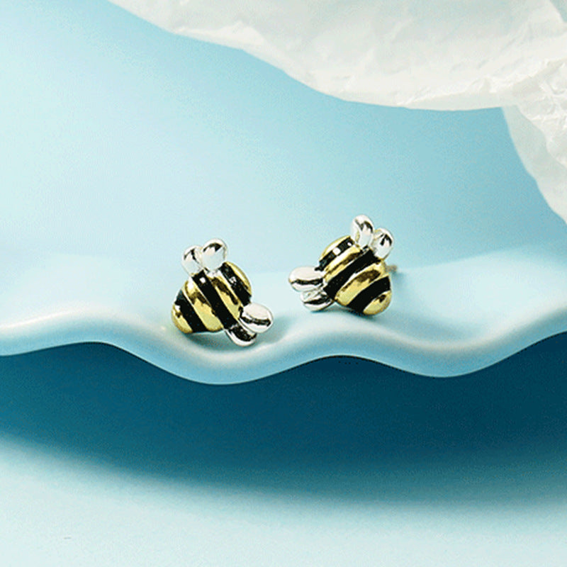 A pair of Special-interest Design Super Cute Little Bee Earrings by Maramalive™ on a blue background.