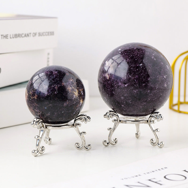 A couple of Maramalive™ Crystal Original Stone Polishing Household Crystal Ball Ornaments sitting on top of a wooden stand.