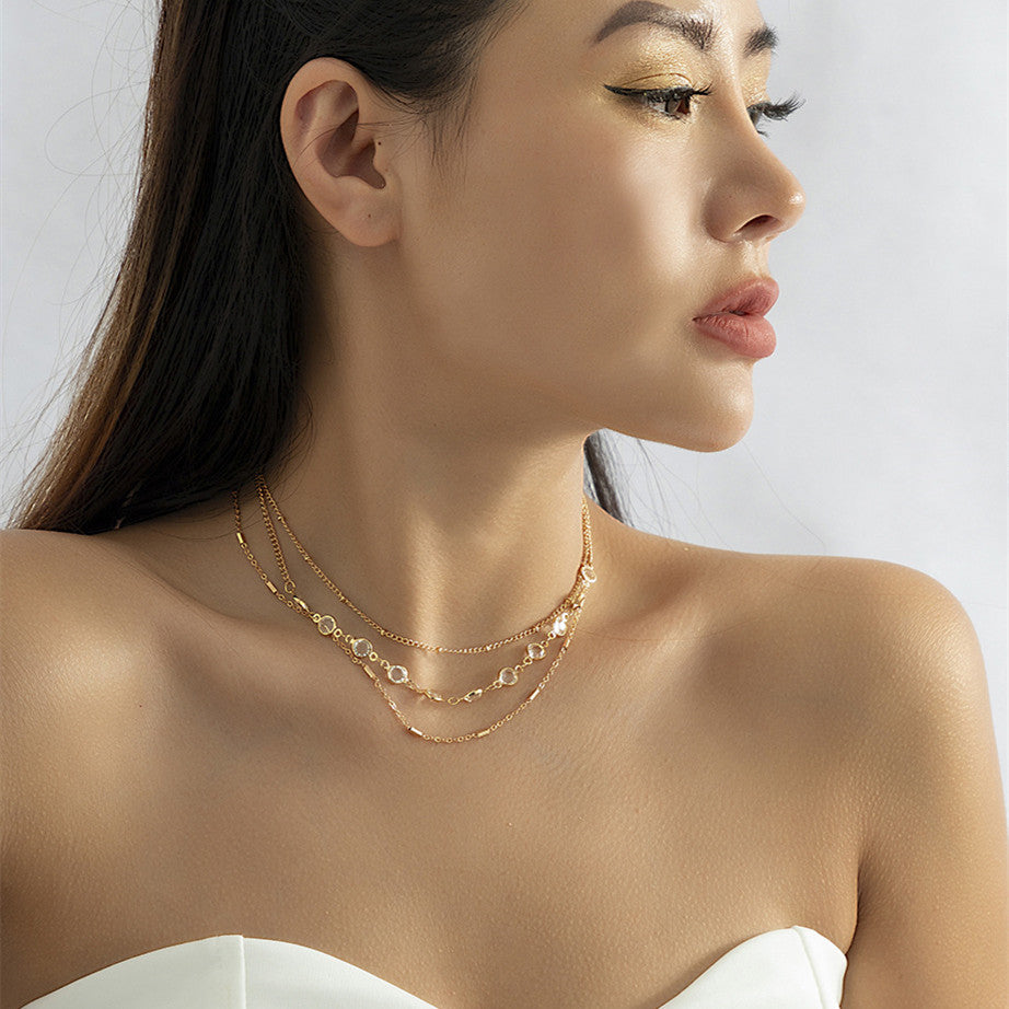 A woman wearing a white dress and Maramalive™ Women's Fashion All-match Simple Crystal Twin Clavicle Chain.