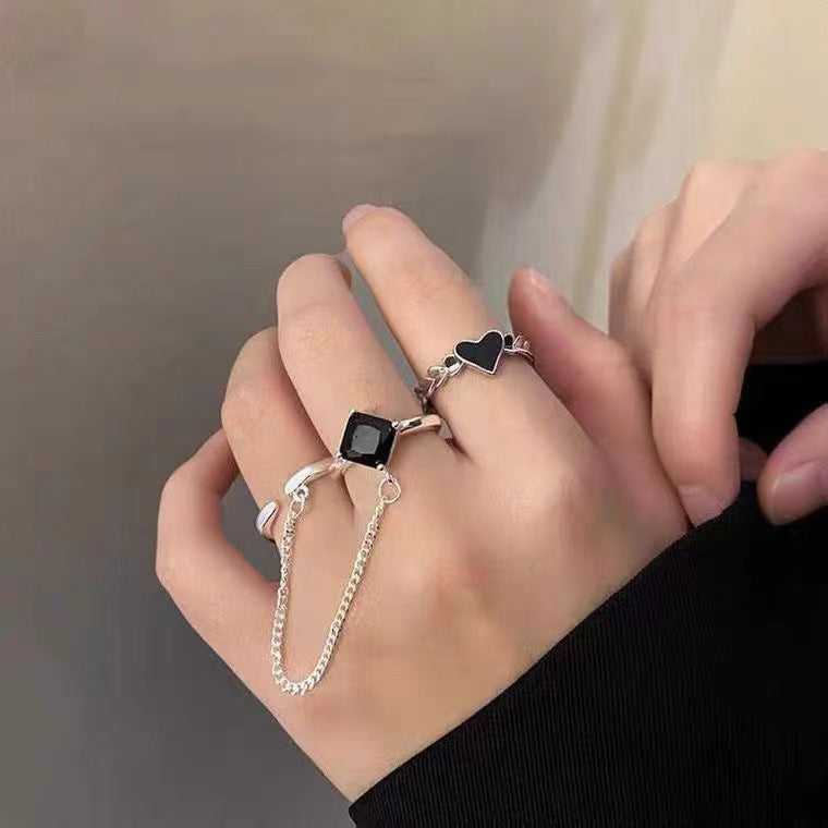 A woman wearing a Maramalive™ Women's Ins Love Minority Fashion Ring with a black stone and silver chain.