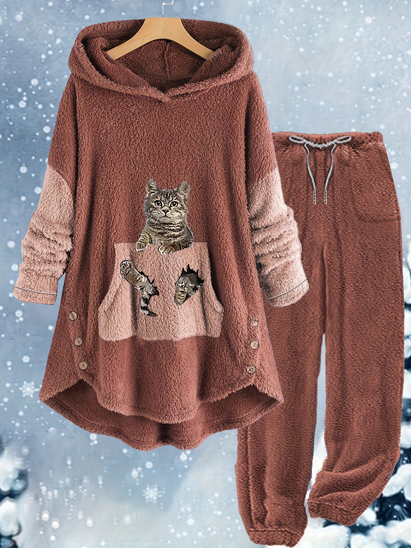 A cozy, brown pajama set with a fuzzy texture, featuring a hooded top with a cartoon cat design on the front pocket and matching pants with a drawstring waist, displayed against a snowy background. Made from soft polyester for ultimate comfort. Introducing the Maramalive™ Plus Size Casual Outfits Two Piece Set, Women's Plus Cat Print Fleece Long Sleeve Button Decor Hoodie & Pants Outfits 2 Piece Set.