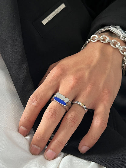 A woman's hand is holding a silver ring and a Maramalive™ Blue Minimalist Ring.