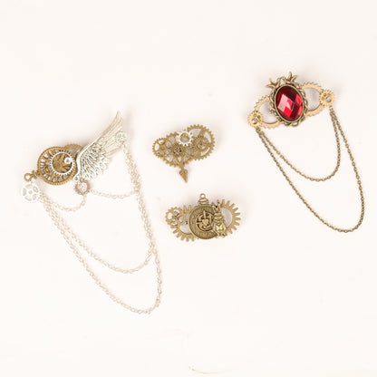 A group of three Maramalive™ Fashion Creative Steampunk Gear Wings Brooches sitting on top of a white table.