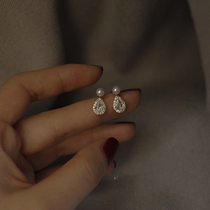 A woman's hand holding a pair of Maramalive™ Sterling Silver Stud Earrings.