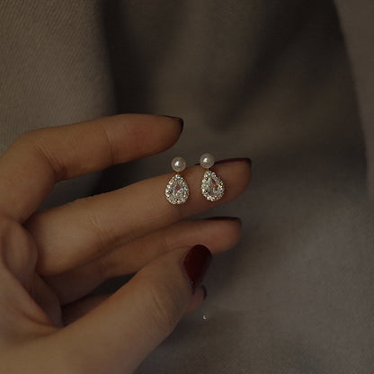 A woman's hand holding a pair of Maramalive™ Sterling Silver Stud Earrings.