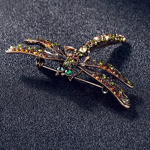 A Vintage dragonfly brooch with green rhinestone and orange stones by Maramalive™.