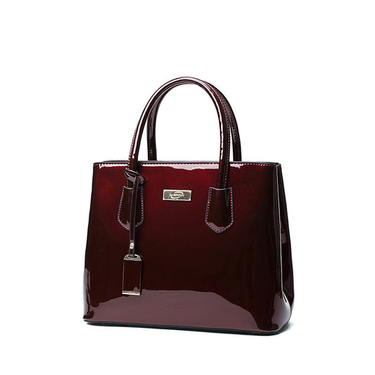 A Patent Leather bag with a metal handle by Maramalive™.