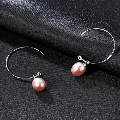 A pair of Maramalive™ Minimalist Earrings on a black surface.