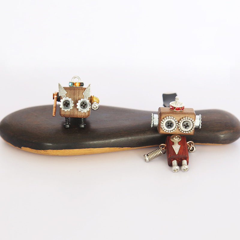 A Steampunk Wooden Robot Car Air Conditioning Accessories hangs from the air vent of a car by Maramalive™.