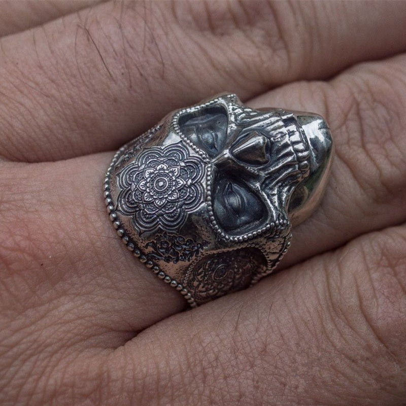 A man's hand is holding a Maramalive™ Discover the Mysteries of the Afterlife with this Striking Sugar Skull Ring.