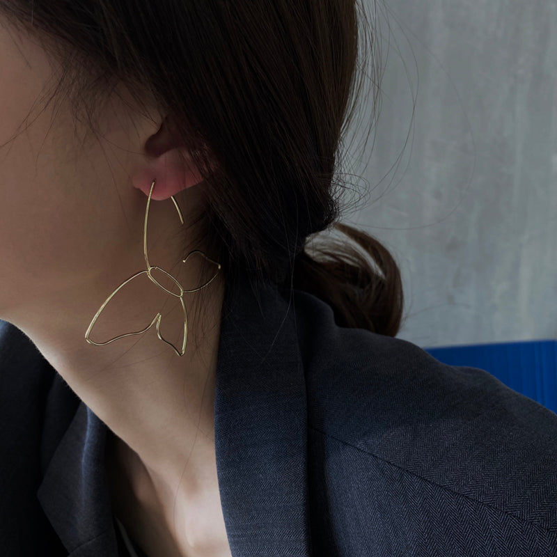 A woman wearing a pair of Maramalive™ Butterfly Hollow Earrings.