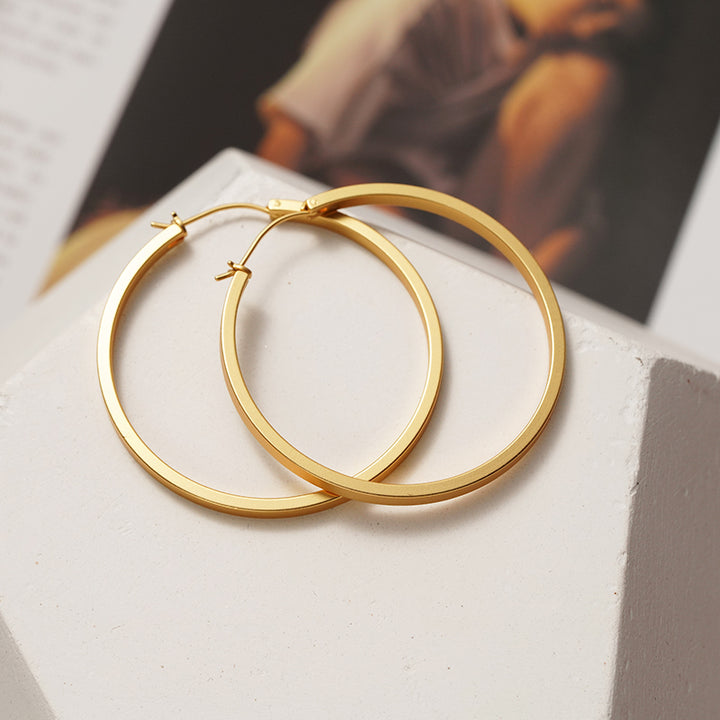 A pair of Maramalive™ Minimalist Circle Ear Buckle earrings on a white surface.