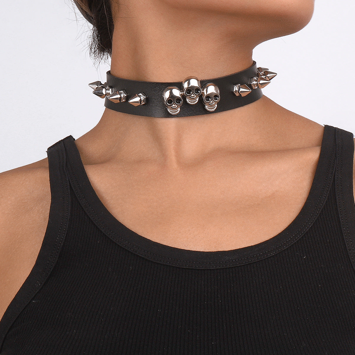 A woman wearing a Gothic Rivet Necklace with skulls and spikes by Maramalive™.