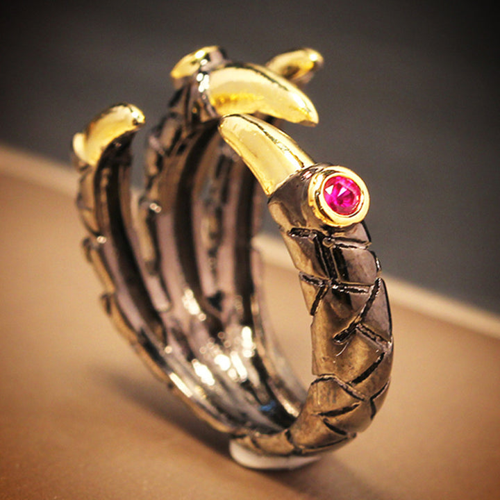 A Dragon Claw Ring from Maramalive™ with claws and a pink stone.