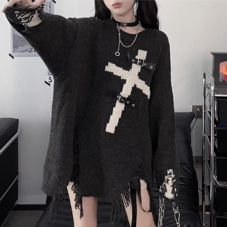 Person wearing an oversized, edgy yet comfortable Maramalive™ Dark Cross Loose Sweater - Comfortable Fit for Women with a white cross detail, black choker, and a ring necklace, standing in a room with a black sofa and metal shelving unit in the background.