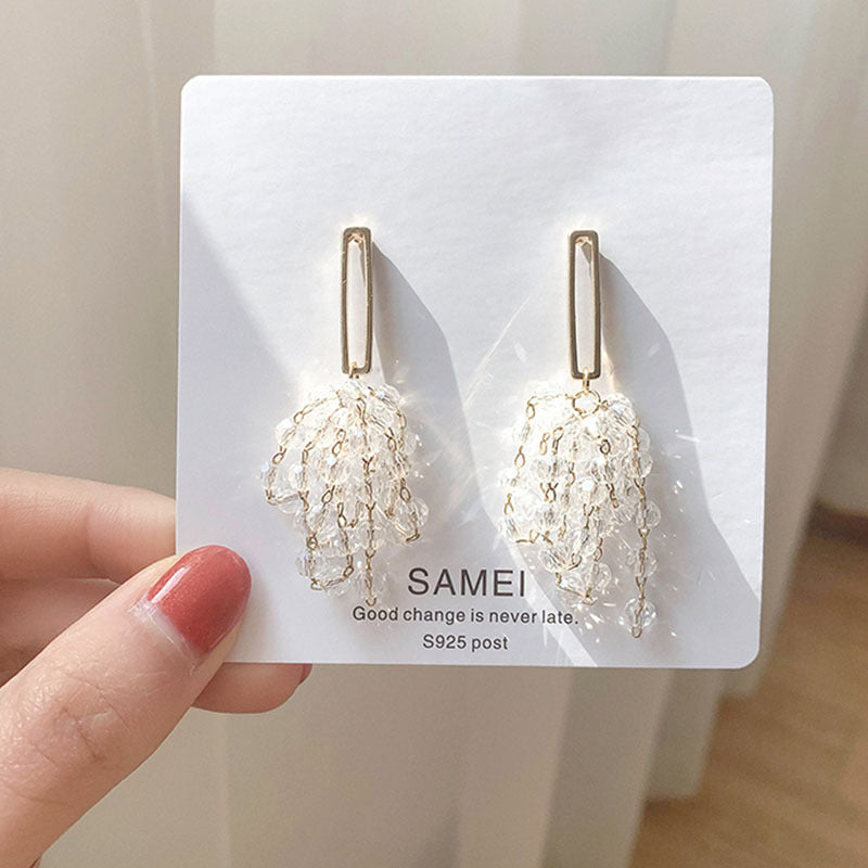 A person holding up a card with a pair of Maramalive™ Tassel Grape Earrings.