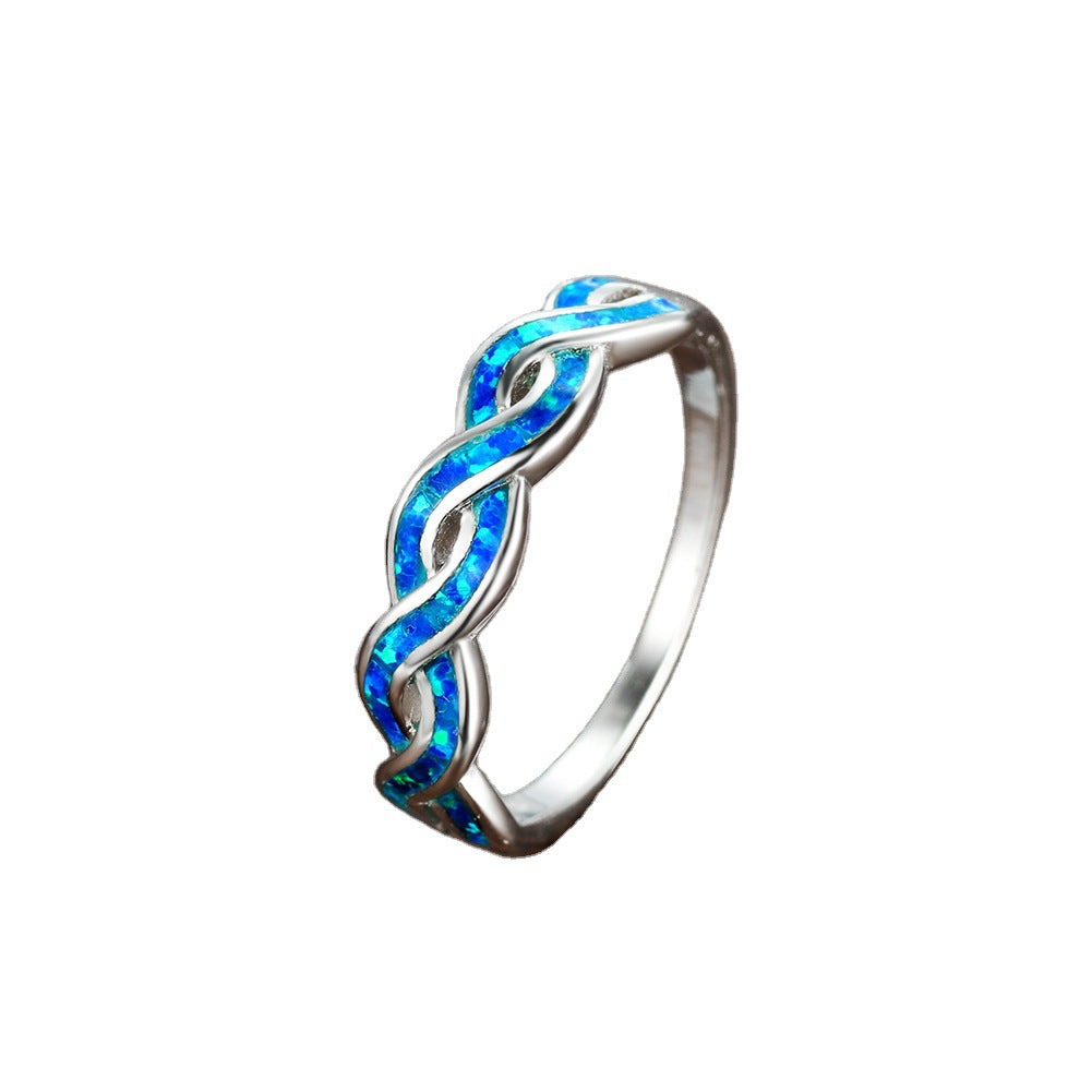 A person holding a blue Maramalive™ Opal Twist Ring.