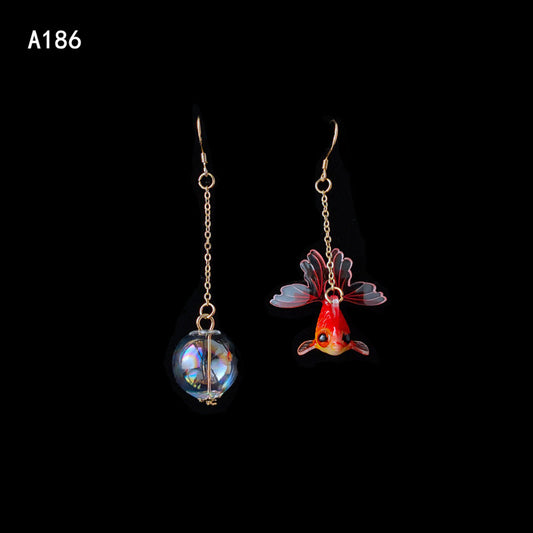 A pair of Goldfish Earrings with a fish and a glass ball by Maramalive™.