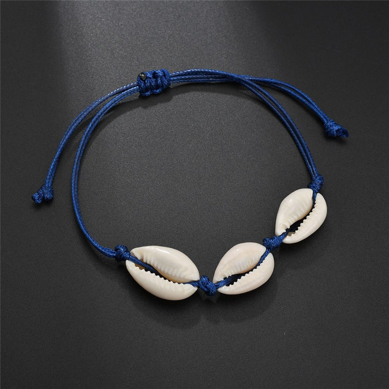 A Double Sea Star Bead Jewelry bracelet with three white shells on a blue cord by Maramalive™.