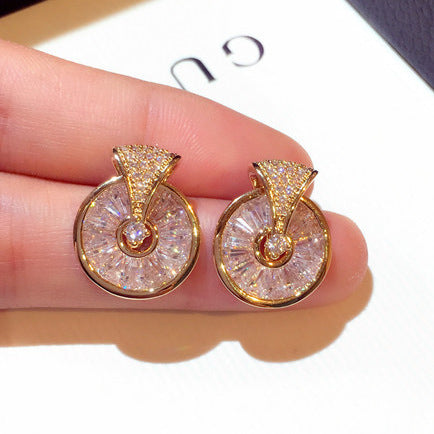 A pair of Maramalive™ diamond stud earrings pendant for women in a box next to a shell.