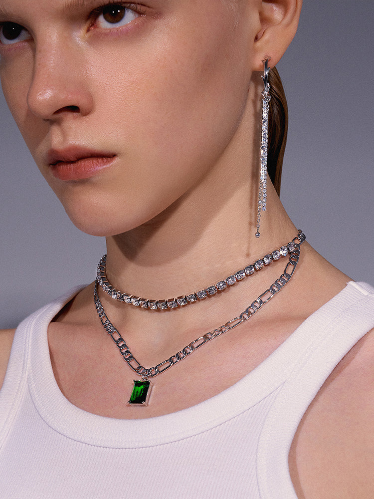 A woman wearing a white top and an Imported Rhinestone Clavicle Chain Necklace - Light Luxury Design with green stones from the brand Maramalive™.