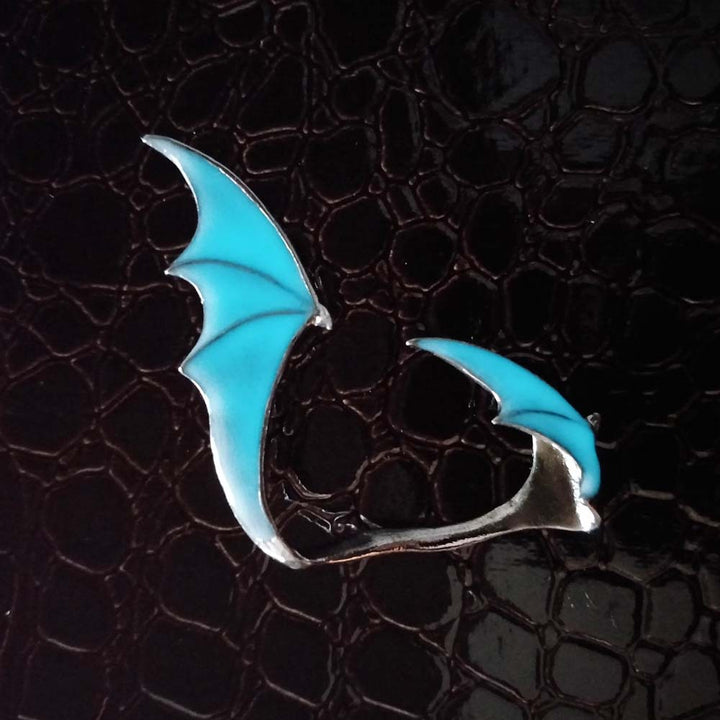 A woman wearing a pair of Glow-in-the-Dark Dragon Wing Earrings from Maramalive™.