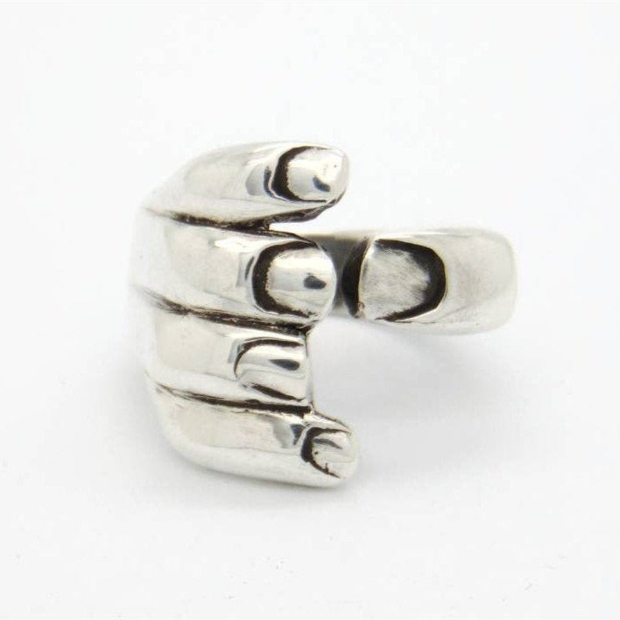 A woman's hand holding a Gothic Carved Hand Ring by Maramalive™.