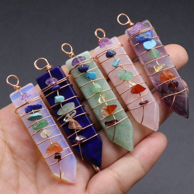 A person is holding a group of different colored Maramalive™ Crystal Arrow Chakra Pendants.