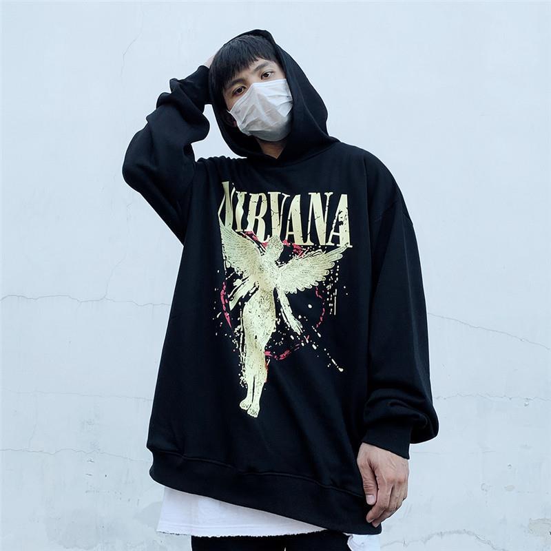 A person wearing an Oversized Punk Style & Hoodie Sweatshirt: Edgy Look by Maramalive™ with a mask stands against a plain background with one hand behind their head.