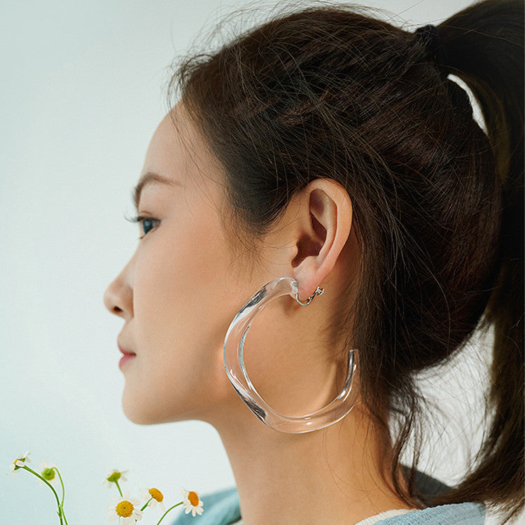 A woman wearing a pair of Maramalive™ Transparent Sea C earrings.