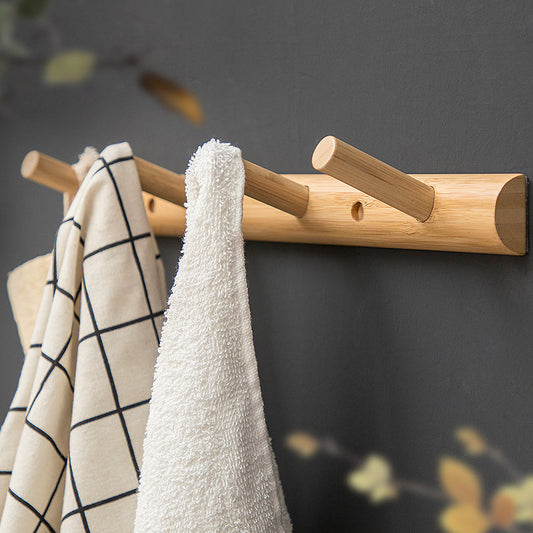 A Maramalive™ bamboo hook viscose hanger behind the door with towels hanging on it.
