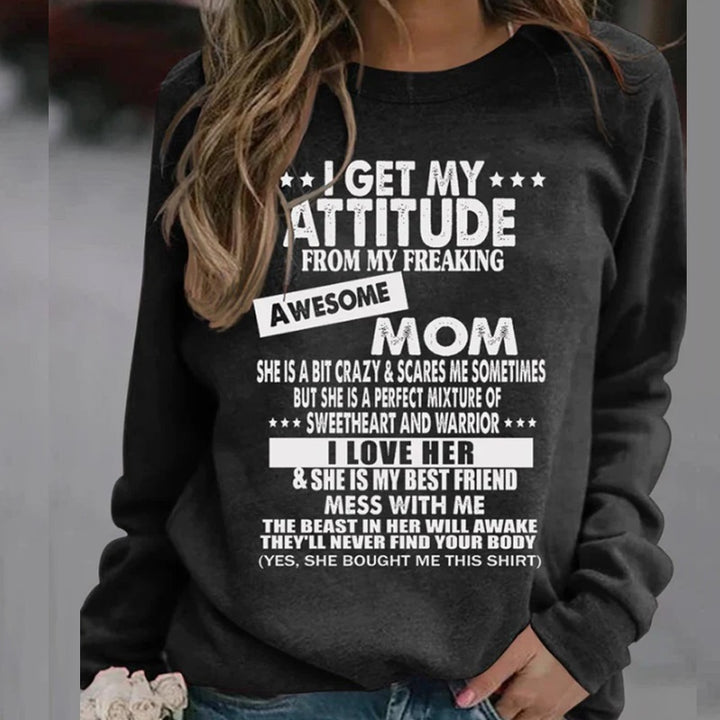 A person wearing a black Maramalive™ I Get My Attitude From My Weird Awesome Mom Sweatshirt with white text that reads: "I GET MY ATTITUDE FROM MY FREAKING AWESOME MOM. She is a bit crazy & scares me sometimes but she is a perfect mixture of sweetheart and warrior..." —a bold statement in street fashion.