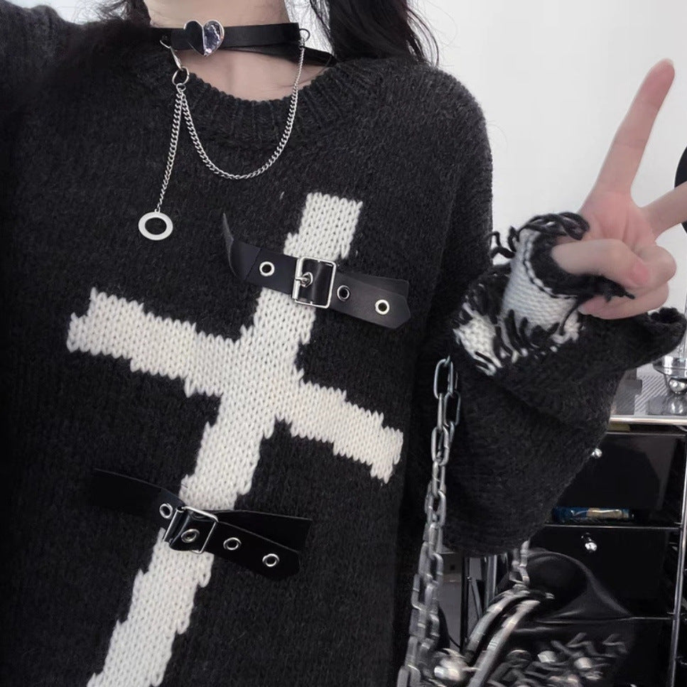 A person wearing an edgy yet comfortable Maramalive™ Dark Cross Loose Sweater - Comfortable Fit for Women with a large white cross design and black buckles. Made from cotton-blend fabric, they are making a peace sign with their right hand and have a chain necklace and choker.