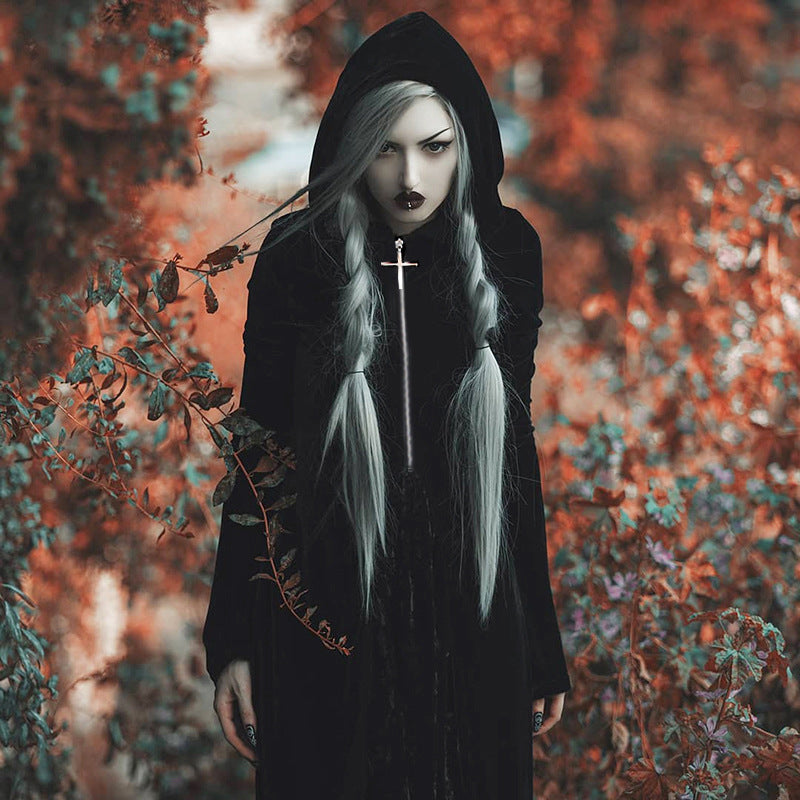 A girl in a Dark Punk Halloween Velvet Cloak - Gothic Underworld Black Cape, by Maramalive™, standing in the dark woods.