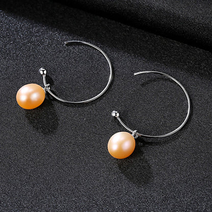 A pair of Maramalive™ Minimalist Earrings on a black surface.