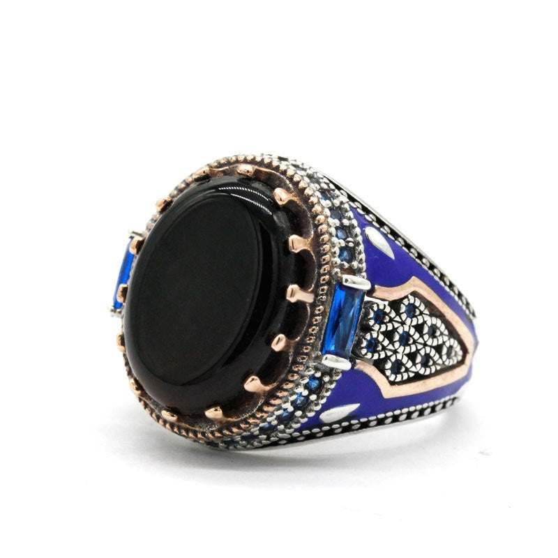 A man's hand is holding a Luxury Business Round Black Onyx Men's Ring by Maramalive™.