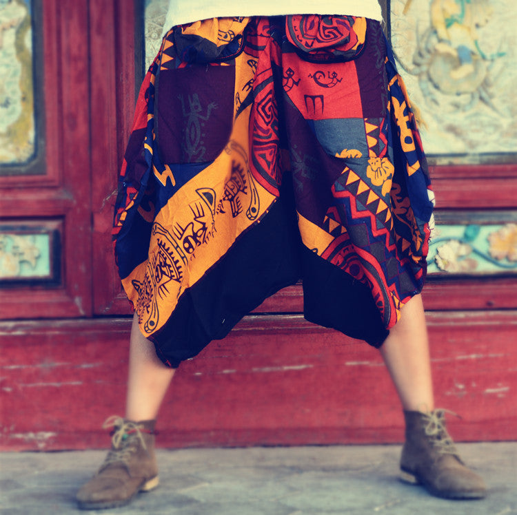 A woman is standing in front of a door wearing a vibrant, Ethnic style hippie graffiti fat oversized cropped pants by Maramalive™.