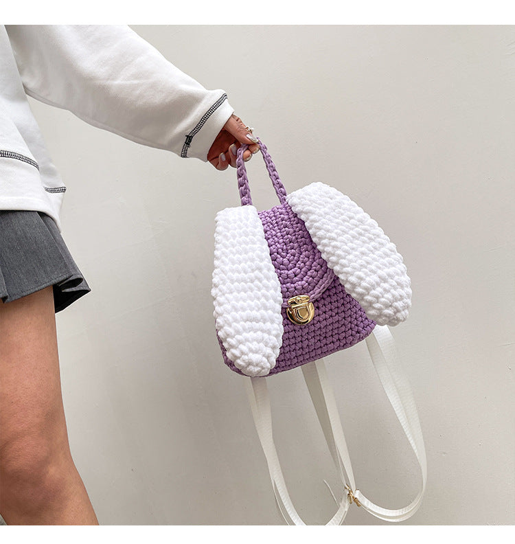 A woman holding a pink Homemade Hand Knitted Lock Cloth Crochet Big Ear Backpack by Maramalive™.