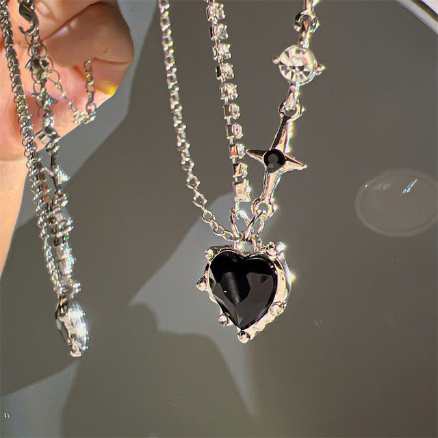 A hand holding a Maramalive™ Niche Creative Personality Affordable Luxury Advanced Love Micro Zircon-laid Necklace with a heart-shaped pendant.