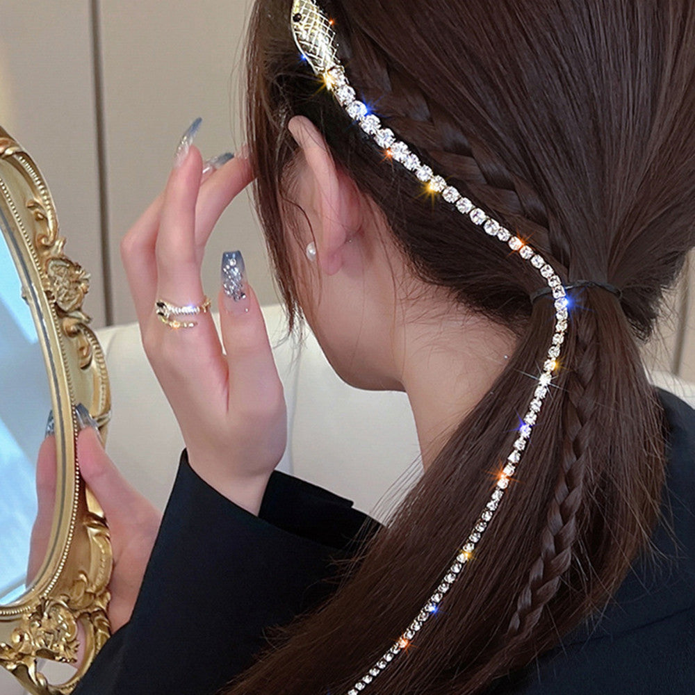 A woman is looking at her hair in the mirror wearing the Maramalive™ Gothic Diamond Tassel Snake Headpiece For Women.