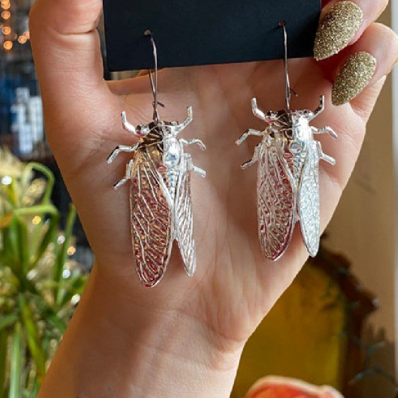 A person holding a pair of Maramalive™ Gothic Cicada Earrings.