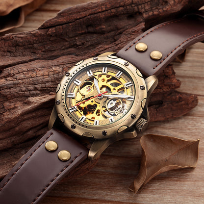 A Maramalive™ Mens Skeleton Steampunk Automatic Mechanical Watch sitting on top of a wooden table.