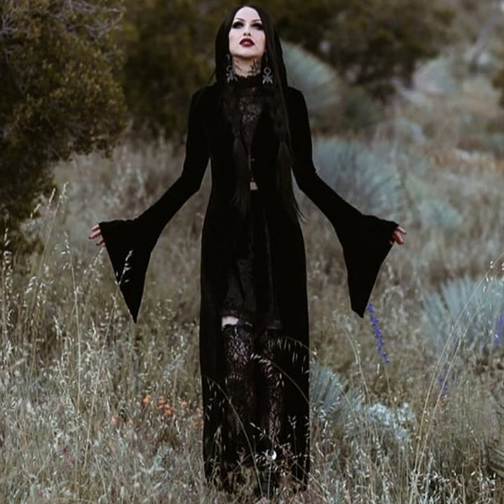 A girl in a Dark Punk Halloween Velvet Cloak - Gothic Underworld Black Cape, by Maramalive™, standing in the dark woods.