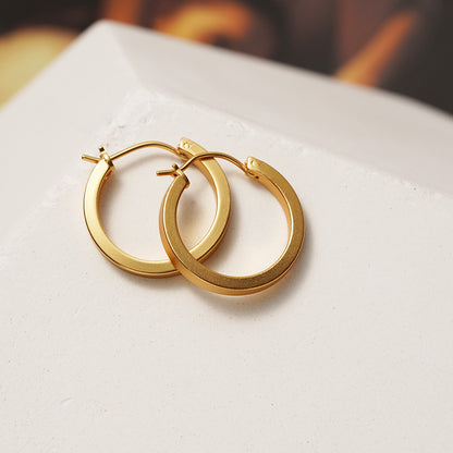 A pair of Maramalive™ Minimalist Circle Ear Buckle earrings on a white surface.