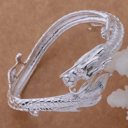 A Maramalive™ sterling silver bangle bracelet with a silver dragon on it.