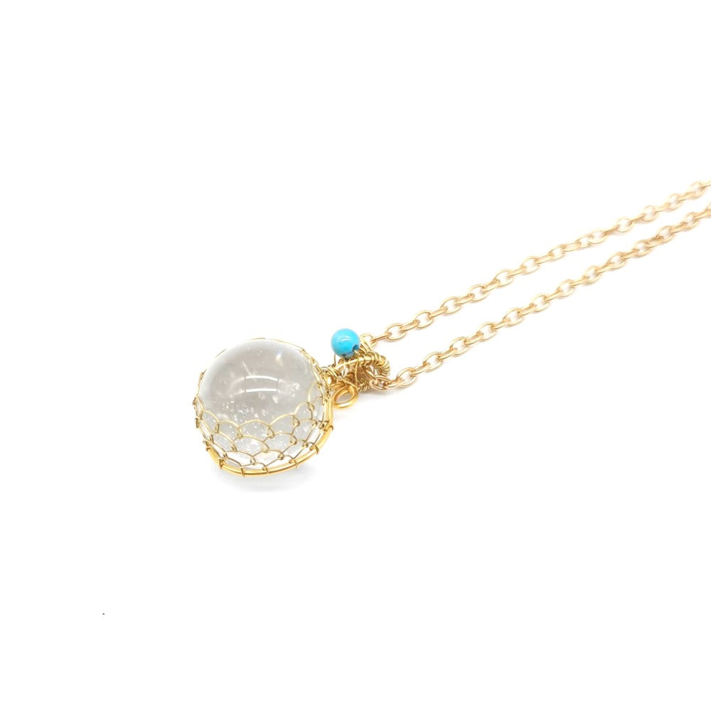 A Crystal Ball Pendant - Natural White necklace with a black stone and turquoise beads by Maramalive™.