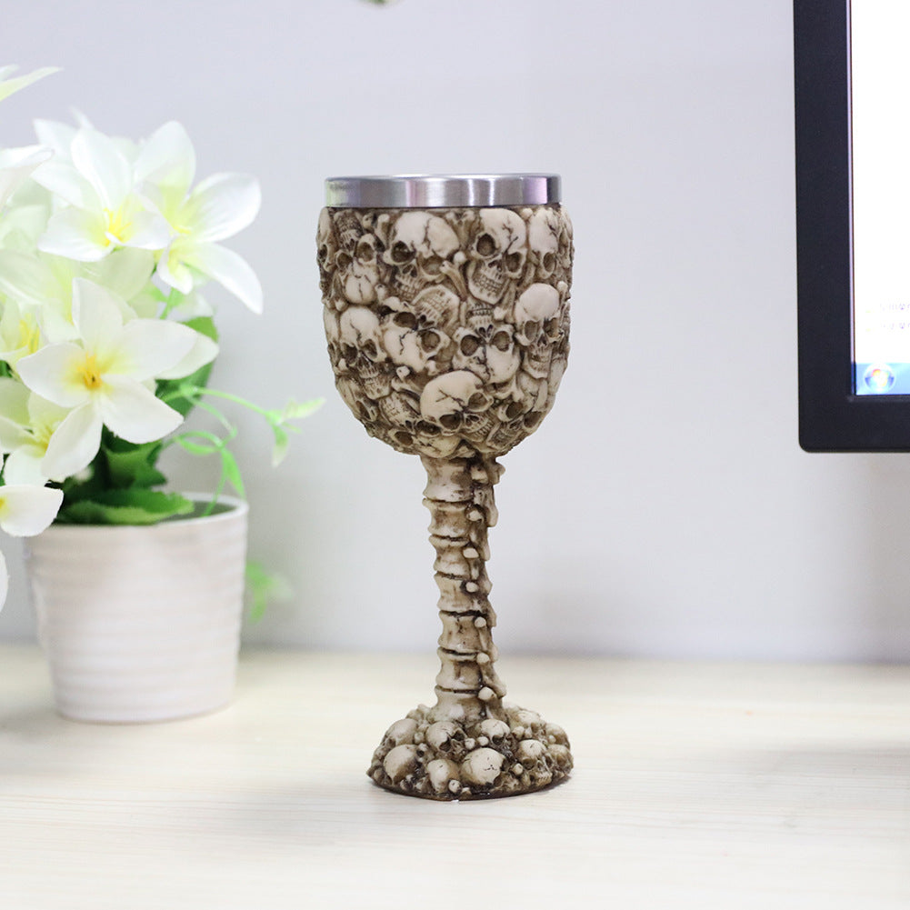 A Personalized Resin Skull Wine Glass by Maramalive™ sitting on a desk.