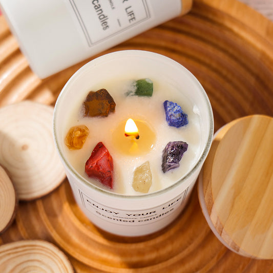 A Maramalive™ scented candle with Natural Crystal Stone Aromatherapy Candle Soy Wax Smokeless Candles Gift Box Christmas Hand Gift on a wooden tray.