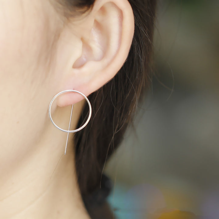 A woman wearing a pair of Maramalive™ Minimalist Copper Earrings.