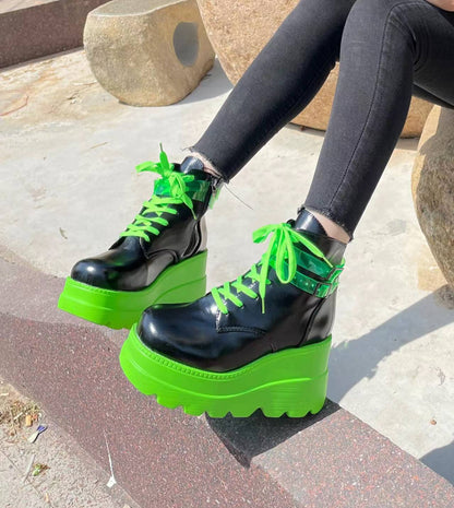 A woman wearing Maramalive™ Dark Gothic Wedge Platform Ankle Boots in a bold black and green color combination, showcasing a unique design.